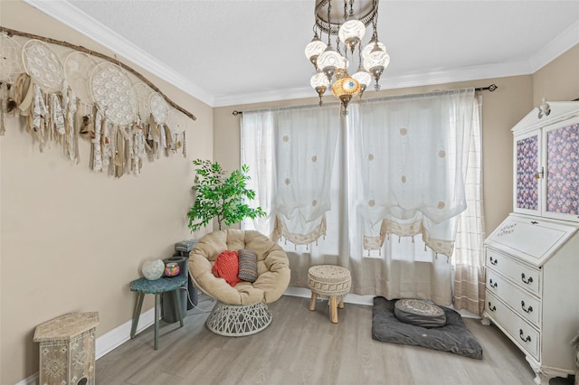 sitting room featuring light hardwood / wood-style flooring, ornamental molding, and a chandelier