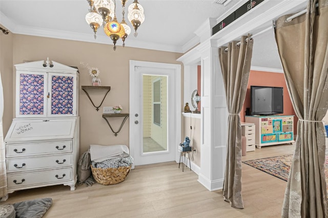 interior space with light hardwood / wood-style floors, ornamental molding, and a notable chandelier