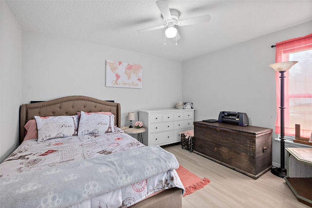 bedroom featuring ceiling fan, a textured ceiling, and light hardwood / wood-style flooring