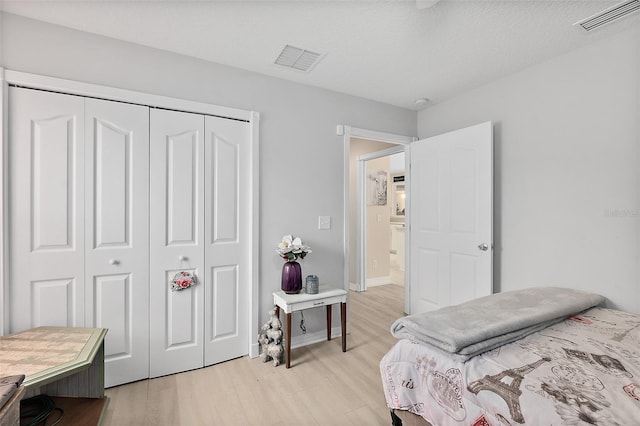 bedroom with a closet and light hardwood / wood-style flooring