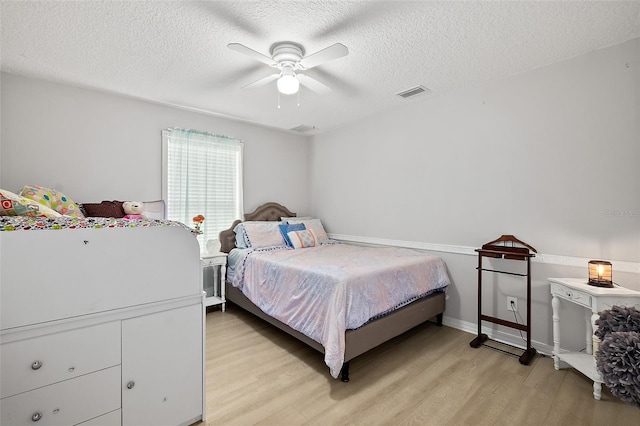 bedroom with ceiling fan, a textured ceiling, and light hardwood / wood-style flooring