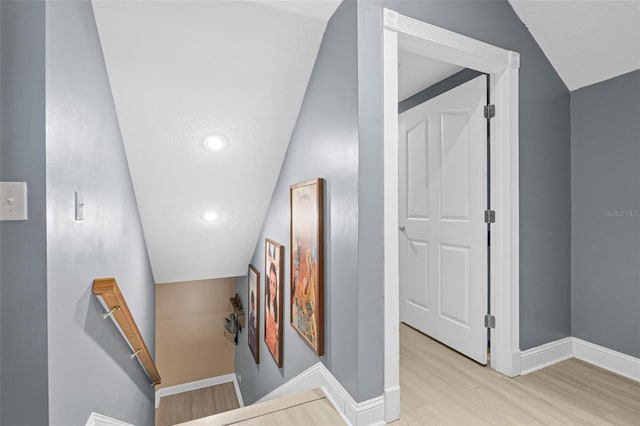 stairs featuring lofted ceiling and wood-type flooring