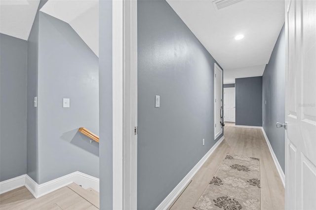 corridor with vaulted ceiling and light hardwood / wood-style floors