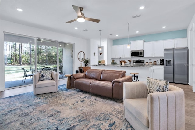 living room featuring ceiling fan and light wood-type flooring