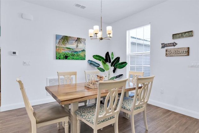 dining space with a chandelier and hardwood / wood-style floors