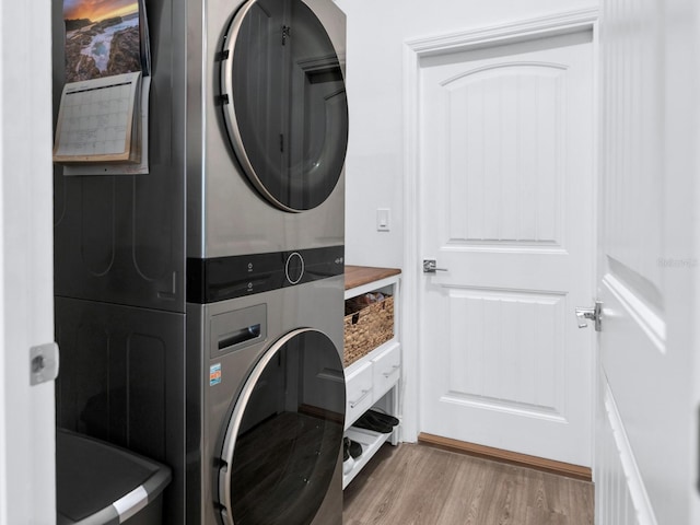 washroom featuring stacked washer / dryer and light hardwood / wood-style floors