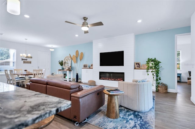 living room featuring a fireplace, dark hardwood / wood-style floors, and ceiling fan