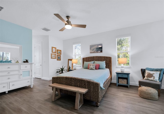 bedroom with multiple windows, dark hardwood / wood-style flooring, and ceiling fan