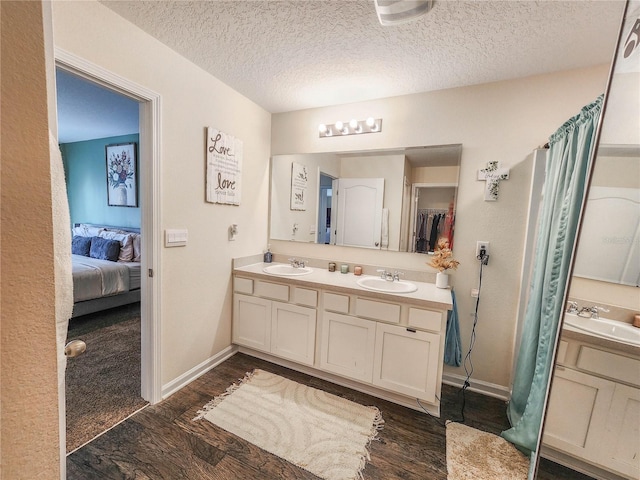 bathroom with vanity, a textured ceiling, and hardwood / wood-style floors