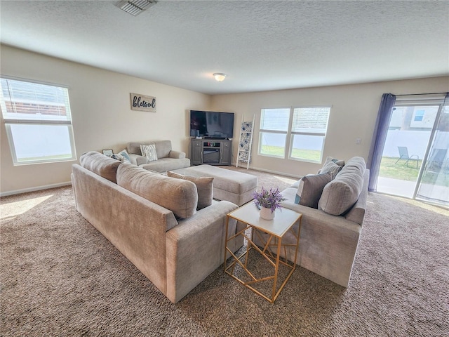 carpeted living room featuring a textured ceiling