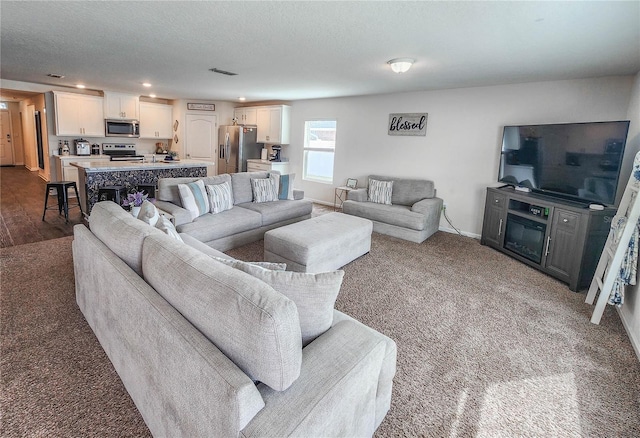 carpeted living room featuring a textured ceiling