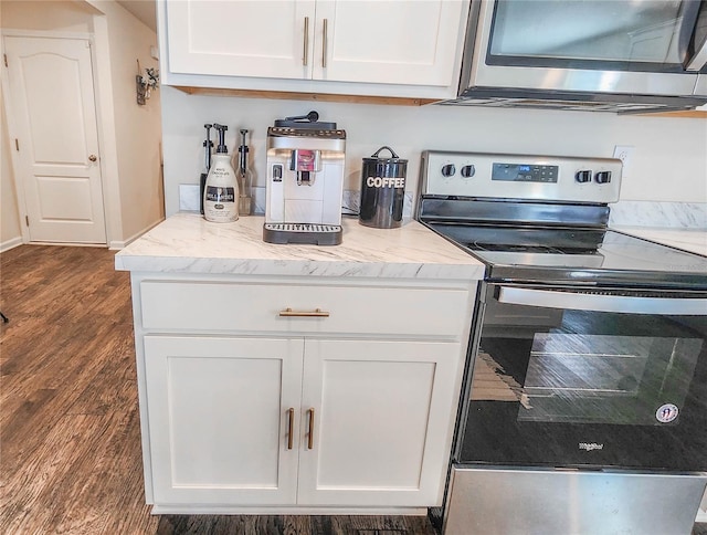 kitchen with light stone countertops, appliances with stainless steel finishes, dark hardwood / wood-style flooring, and white cabinetry