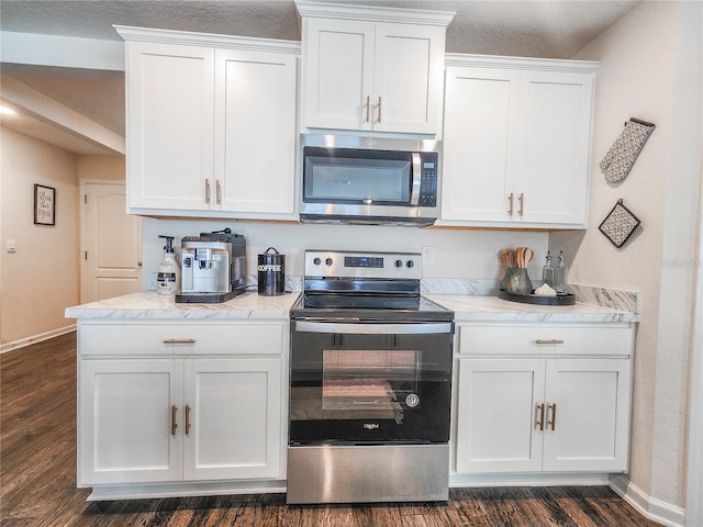 kitchen featuring dark wood-type flooring, appliances with stainless steel finishes, white cabinets, and light stone counters