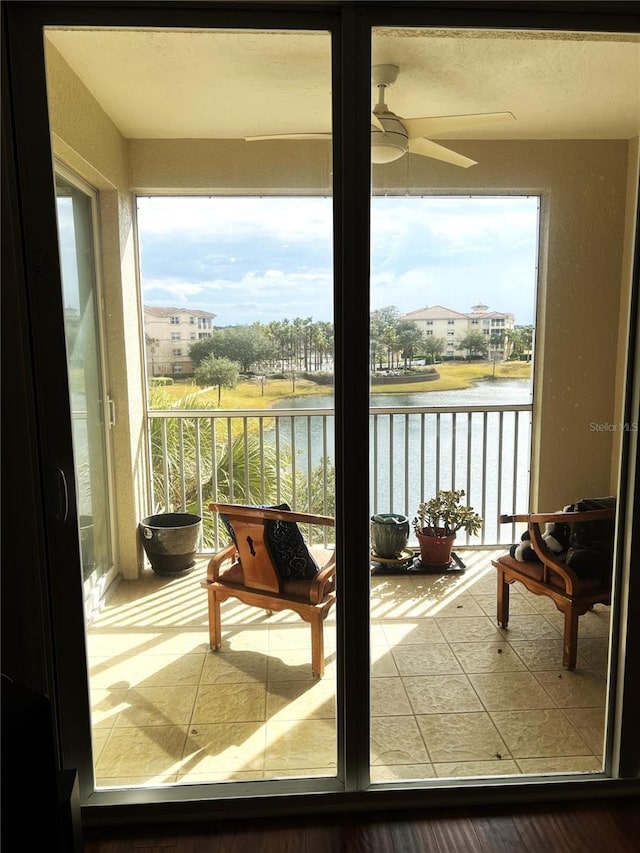 balcony with a water view and ceiling fan