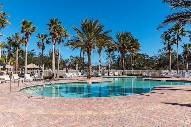 community pool with fence and a patio