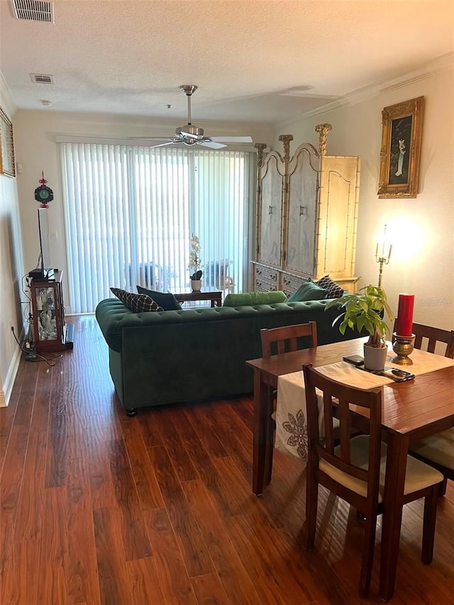 living room featuring ceiling fan, a textured ceiling, wood finished floors, and visible vents