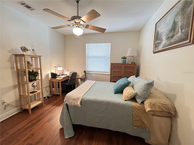 bedroom featuring a textured ceiling, ceiling fan, wood finished floors, visible vents, and baseboards