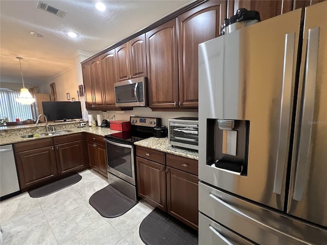 75 Riverview Bnd S Unit 1633, Palm Coast, FL 32137 - kitchen featuring appliances with stainless steel finishes, a sink, light stone counters, hanging light fixtures, and dark brown cabinets