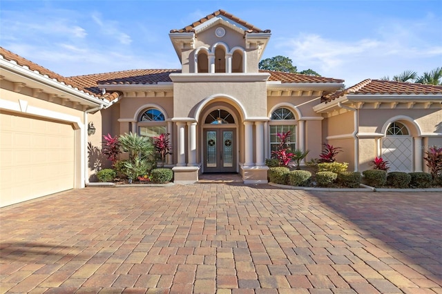 mediterranean / spanish-style home featuring a garage and french doors