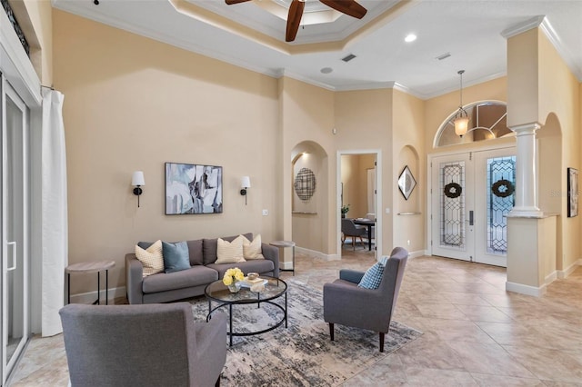 living room featuring ceiling fan, a high ceiling, ornamental molding, and french doors