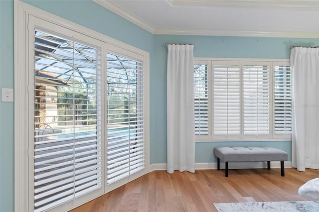 living area with plenty of natural light, light hardwood / wood-style flooring, and ornamental molding