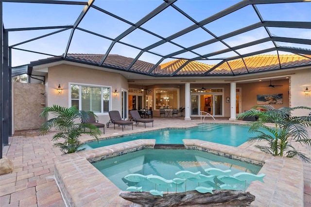 back of house featuring a lanai, ceiling fan, a patio area, and a swimming pool with hot tub