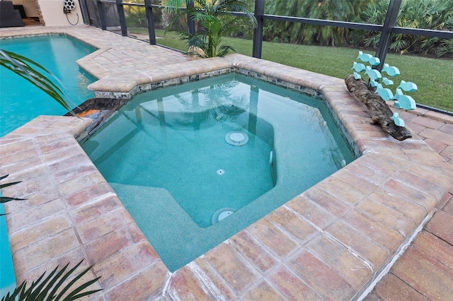 view of pool with a lanai, a lawn, and an in ground hot tub