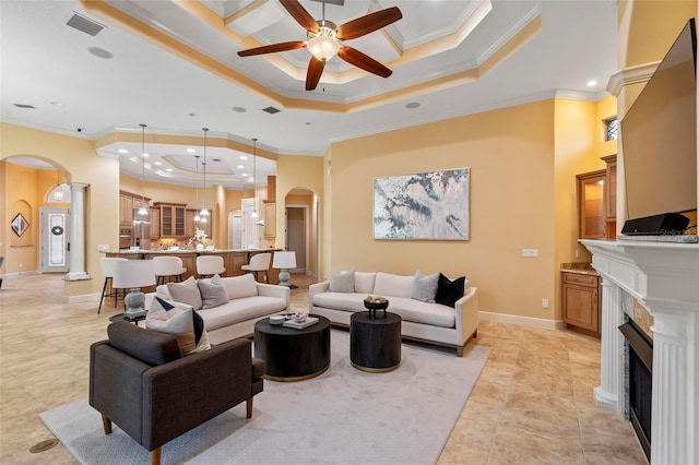 living room with ceiling fan, ornamental molding, coffered ceiling, and a tray ceiling