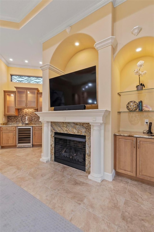 unfurnished living room with beverage cooler, crown molding, and a premium fireplace