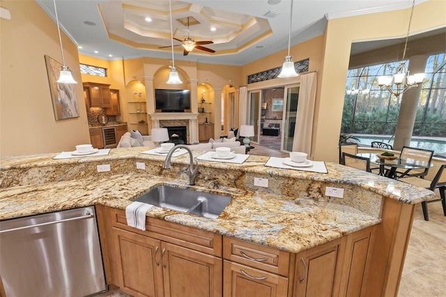 kitchen featuring light stone counters, sink, dishwasher, and ornamental molding