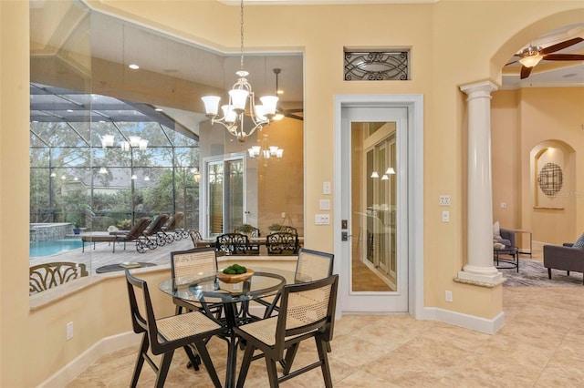 dining area featuring ornate columns and ceiling fan with notable chandelier