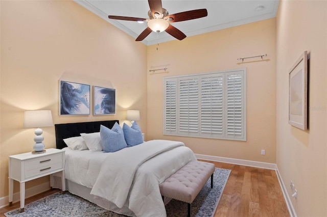 bedroom featuring ceiling fan, wood-type flooring, and crown molding