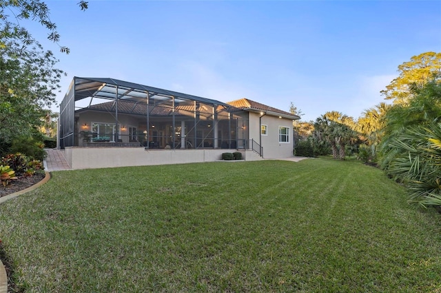 back of house with a lanai and a yard