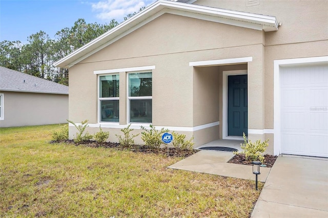 entrance to property with a garage and a yard