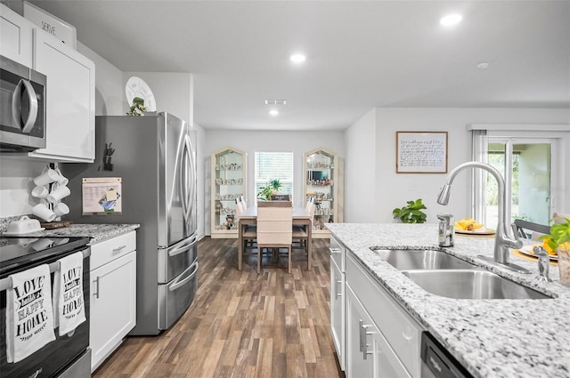 kitchen with plenty of natural light, appliances with stainless steel finishes, white cabinets, and sink