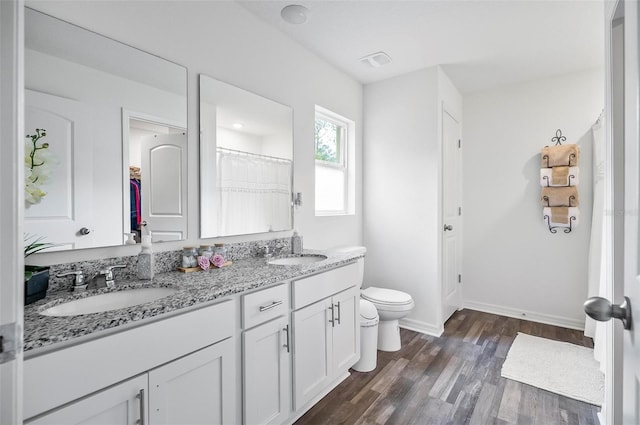 bathroom featuring toilet, vanity, curtained shower, and hardwood / wood-style floors