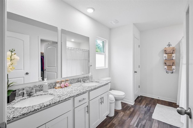 bathroom with hardwood / wood-style floors, toilet, and vanity