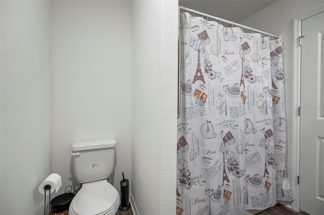 bathroom featuring toilet and a shower with curtain