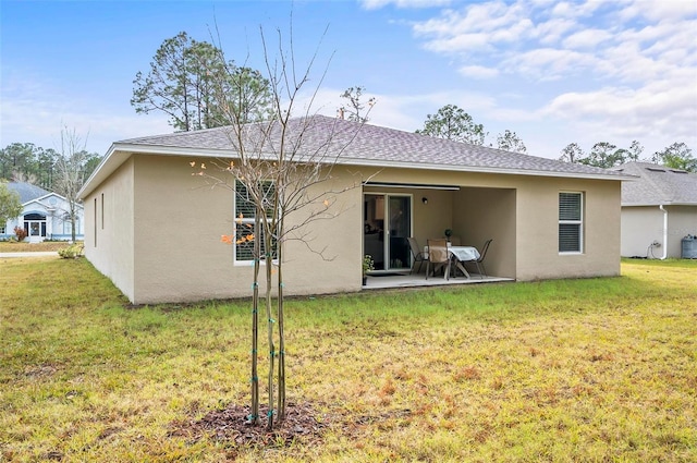 back of house featuring a patio area and a lawn