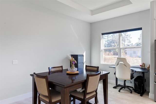 dining area with a raised ceiling and a wealth of natural light