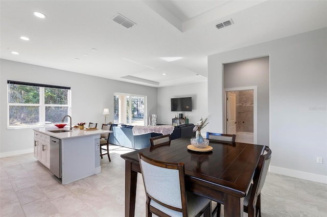 dining area featuring a raised ceiling and sink