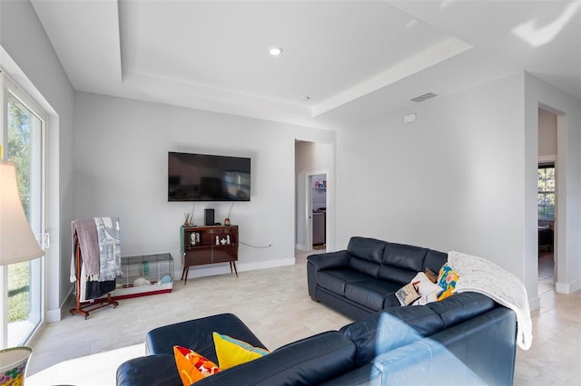 living room with a healthy amount of sunlight and a raised ceiling