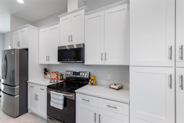 kitchen with stainless steel appliances, white cabinets, and light tile patterned flooring