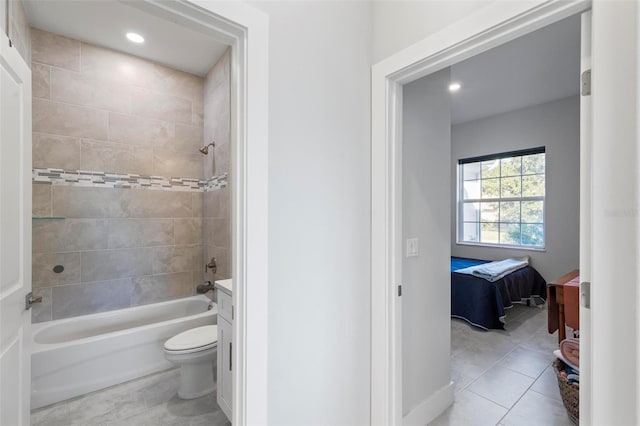 full bathroom featuring tile patterned flooring, vanity, tiled shower / bath combo, and toilet