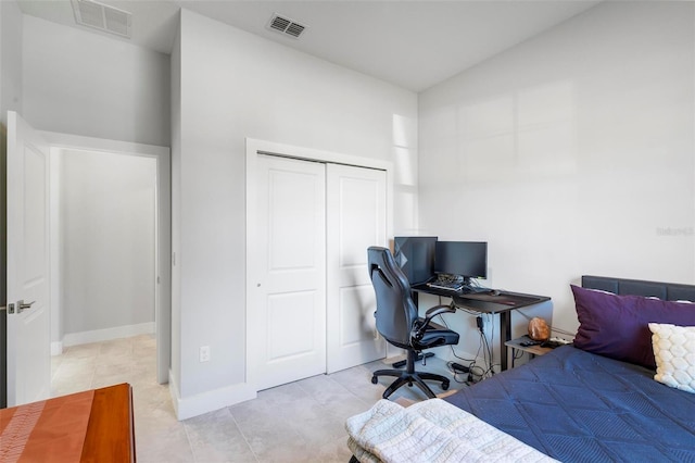 bedroom featuring vaulted ceiling, a closet, and light tile patterned floors