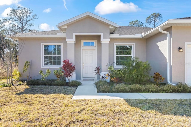 entrance to property featuring a yard