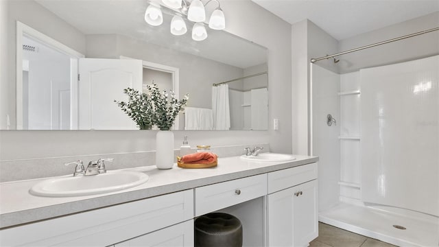 bathroom with a shower with shower curtain, tile patterned floors, and vanity