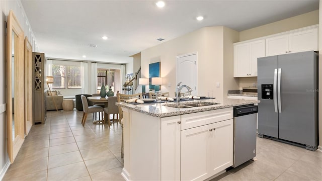 kitchen featuring sink, white cabinetry, a center island with sink, and stainless steel appliances