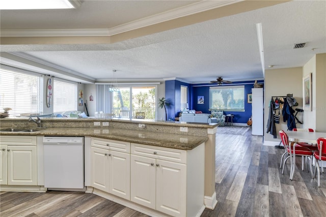 kitchen featuring sink, white dishwasher, white cabinetry, and ornamental molding