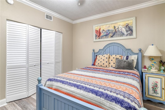 bedroom with a closet, crown molding, a textured ceiling, and hardwood / wood-style floors